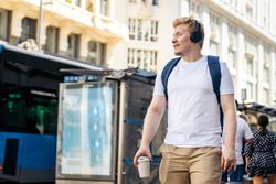 Latino man with albinism walking down the street in light colored clothes