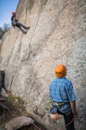 Climbers in safety harness climbing mountain