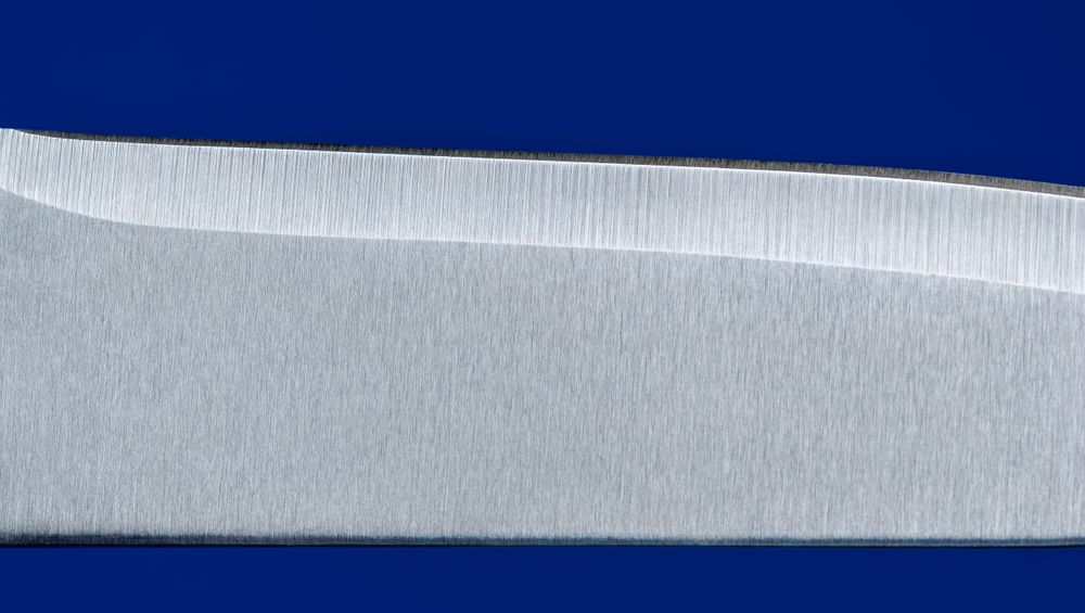 Knife blade close up, isolated on a blue background