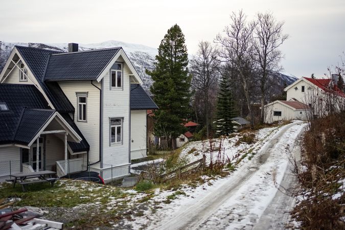Amazing wintry view of countryside with colorful cottages against snowy hills