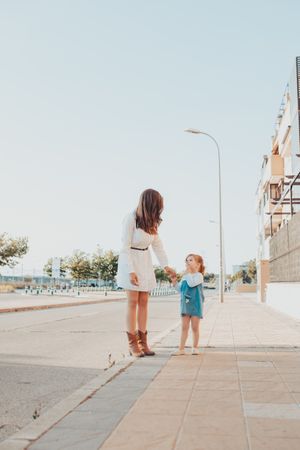 Mother and daughter standing on street