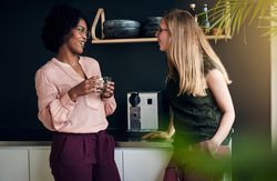 Two colleagues having a lively conversation in the office break room