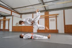 Two people with mask and kimono practicing krav maga