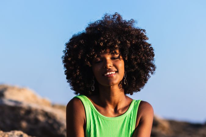 Black woman in swimsuit and with hat on beach