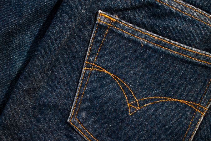 Close up Back pocket of navy blue jeans fabric texture background