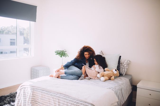 Mother and daughter reading on a bed