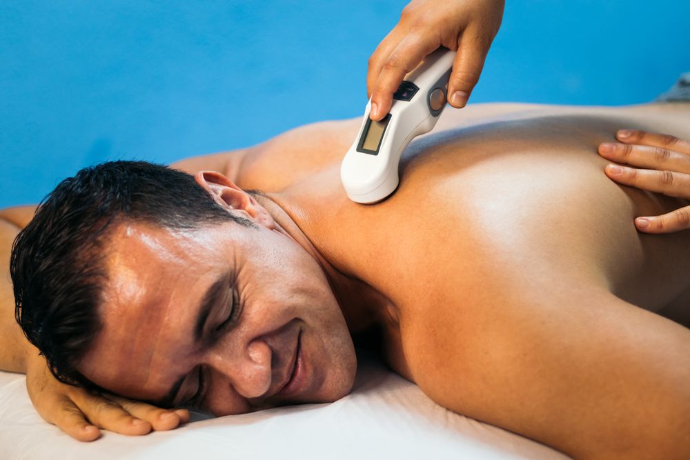 Ultrasound in Physical Therapy. Therapist Using Ultrasound Applicator on a Patient Lower Back