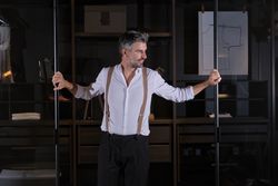 Gray haired male standing in glass doorway at home