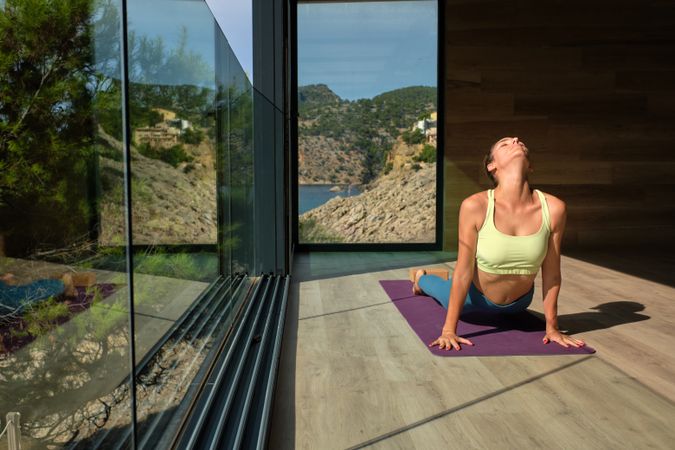 Serene woman practicing yoga in Bhujangasana at home