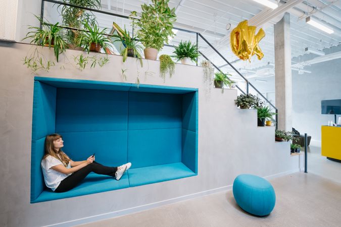 Woman with phone in cozy niche in office