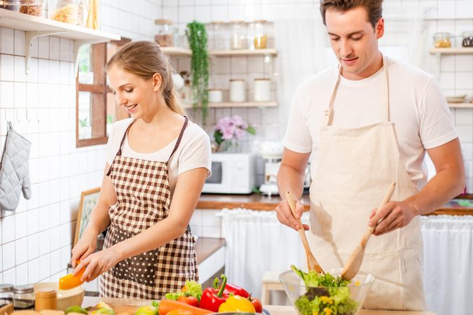 Man and woman preparing a salad at home