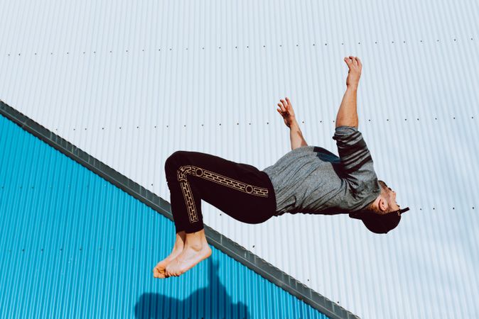 Trendy male flipping on street