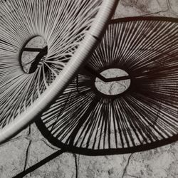 Modern wicker chair leaving shadow on stone pavement