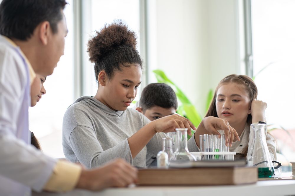 Diverse group of students with beakers in science class