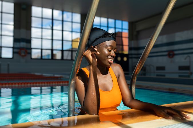 Black woman coming out of the swimming pool and resting