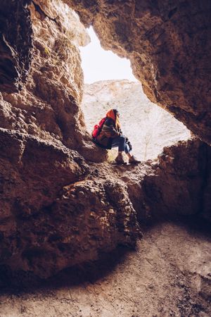 Relaxed tourist woman entering mountain cave