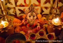 Small statue of Lakshmi Hindu Goddess surrounded by diya and flowers 5RJwR5