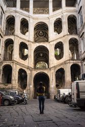 Faceless female on vacation looking at ancient impressive palace