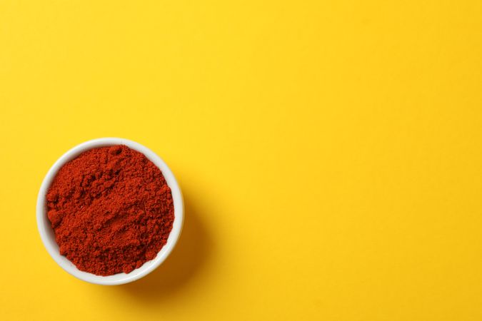 Top view of red pepper powder in ceramic bowl, copy space