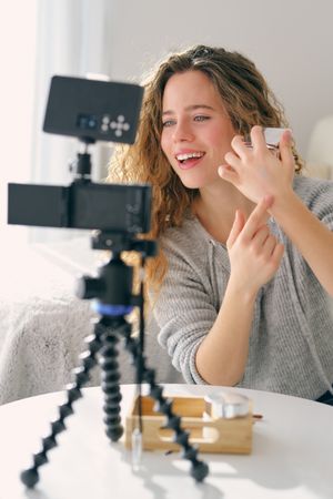 Female vlogger testing moisturizing cream on hand