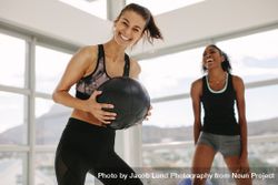 Smiling women working out in fitness studio with medicine ball bxAqpy
