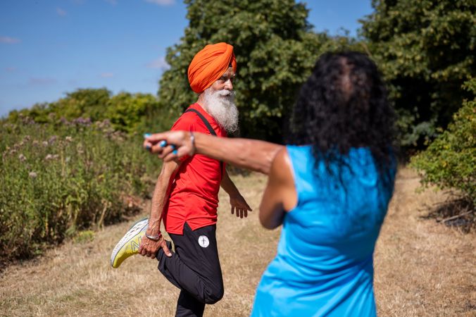 Mature Sikh couple stretching outside