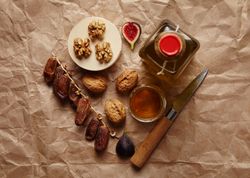 Top view of walnuts, honey, dates, olive oil and dates