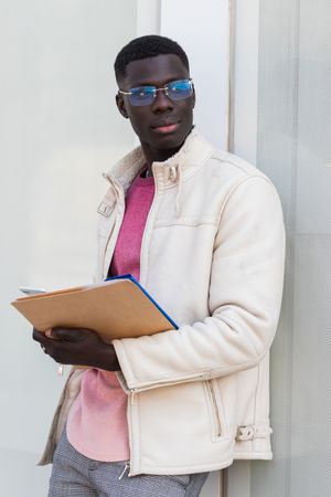 Black businessman with documents on clipboard in city