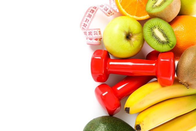 Dumbbells, measuring tape and fruits isolated on plain background