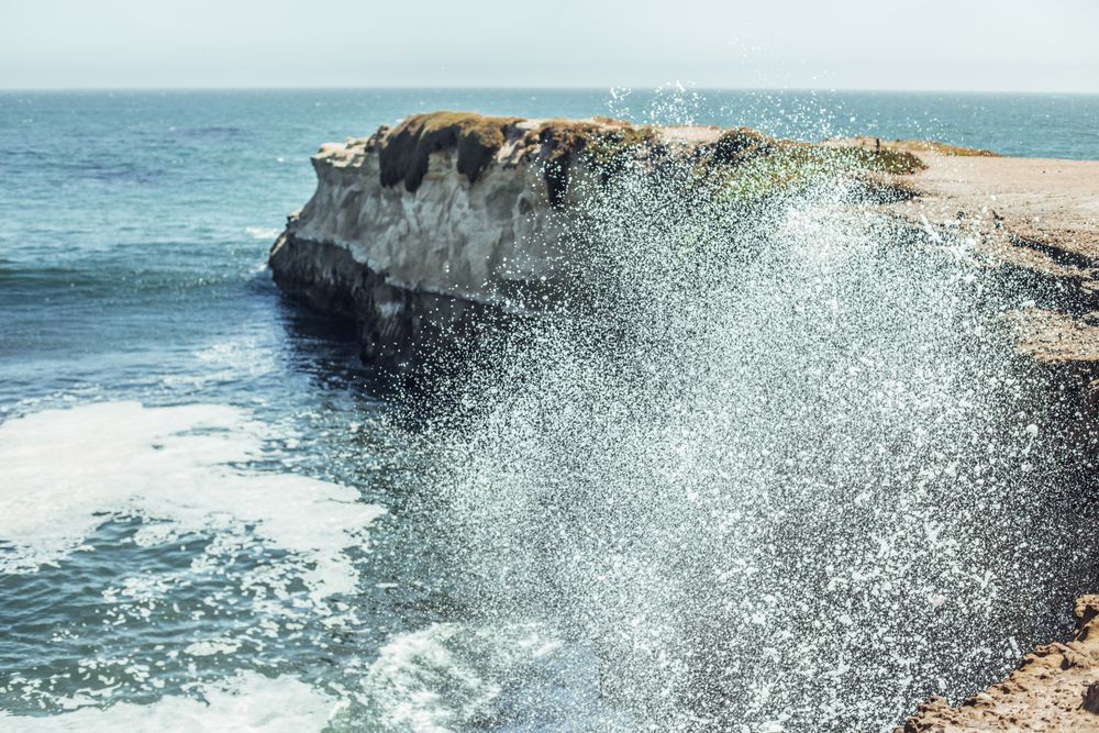 Water with splashes near coast in sunny day