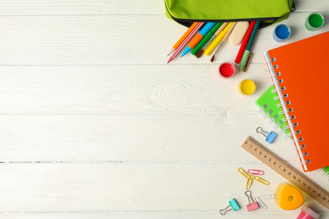 Flat lay composition with school supplies on plain wooden background, space for text