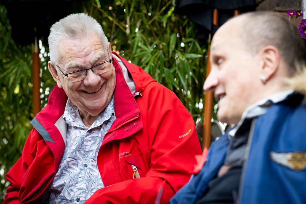 Two older male friends talking outside