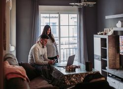 Couple expecting baby using gadgets at home