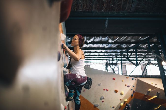 Woman bouldering at indoor climbing center