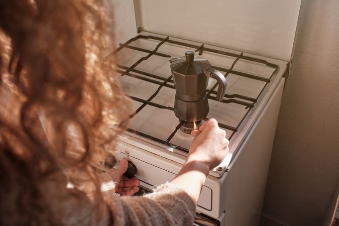 Unrecognizable woman brewing coffee in moka pot
