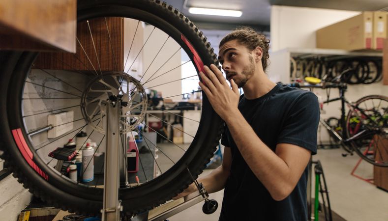Worker fixing a bicycle in workshop