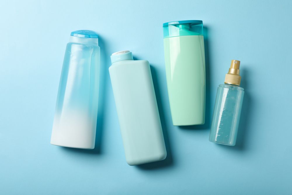 Blank bottles of cosmetics on blue background
