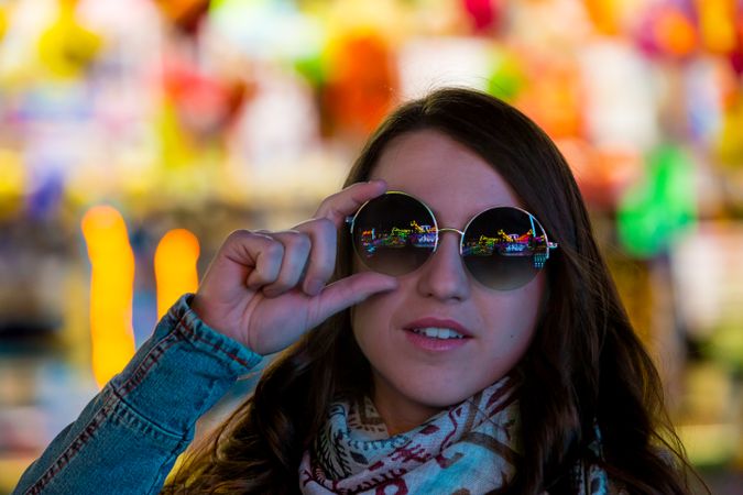 Stylish young woman near illumination on street