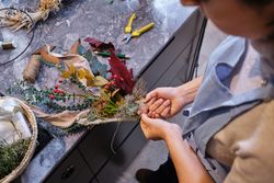 Anonymous woman making creative composition in floristry store