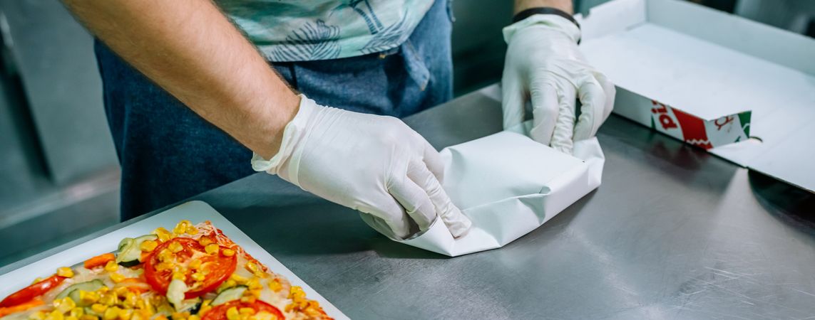 Unrecognizable cook packing takeaway orders