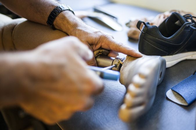 man fixing a prosthesis in a workshop