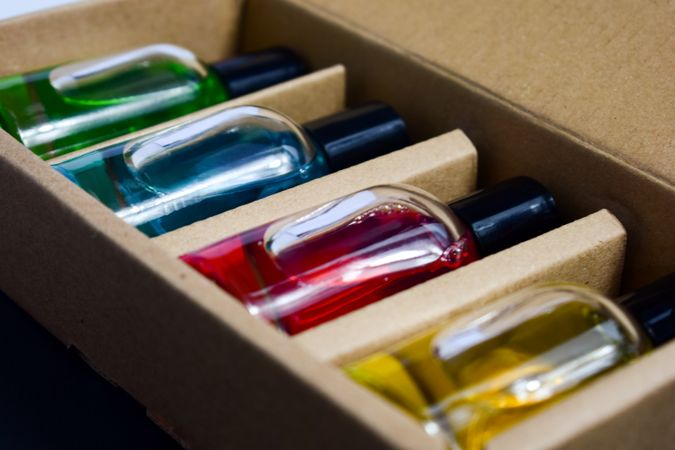 Four colorful perfume bottles in a box