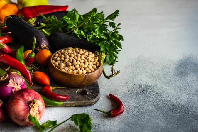 Fresh colorful vegetables and beans on wooden board with copy space