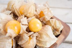 Cape gooseberry (Physalis) in wooden bowl on wooden table, healthy fruit and vegetable