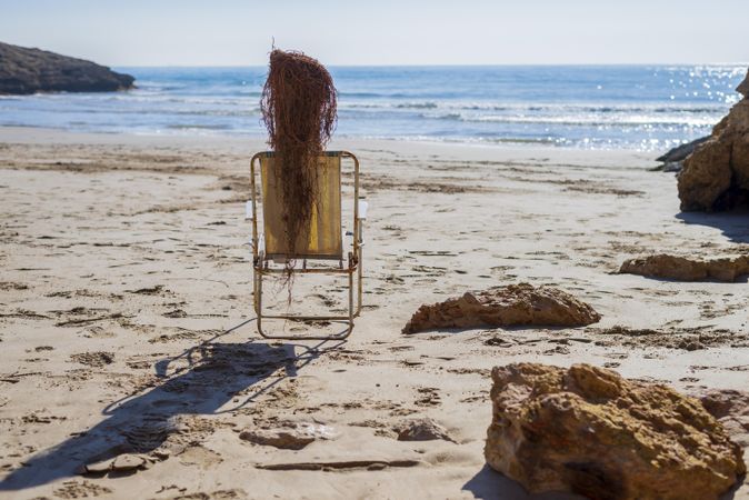 Back of beach chair with driftwood and net