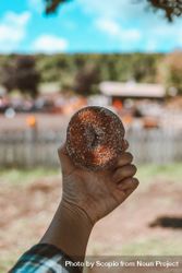 Cropped image of person holding round donut outdoor bEXzG4