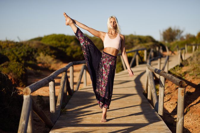 Woman stretching on wooden bridge