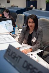 Flight director Ginger Kerrick monitors controllers on console in mission control 42kGqb