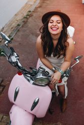 Woman smiling with face up sitting on motorbike