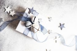 Top view of wrapped Christmas present with bell and star ornament